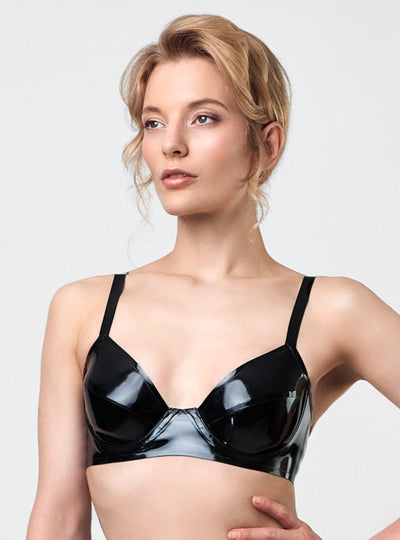 Model in Strict Latex Bra in black latex with straight frame, wired unpadded balconette cups and hook closure. Handcrafted in Berlin.